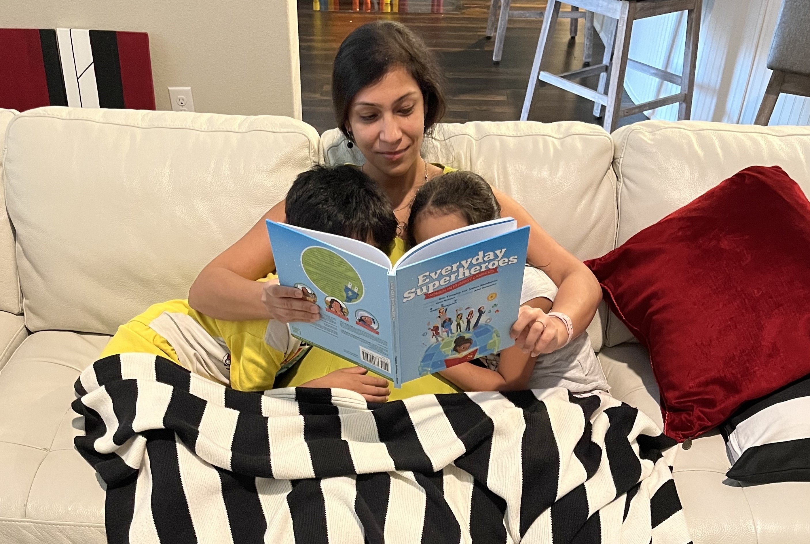 Arthi Vasudevan reading to her two children on the couch